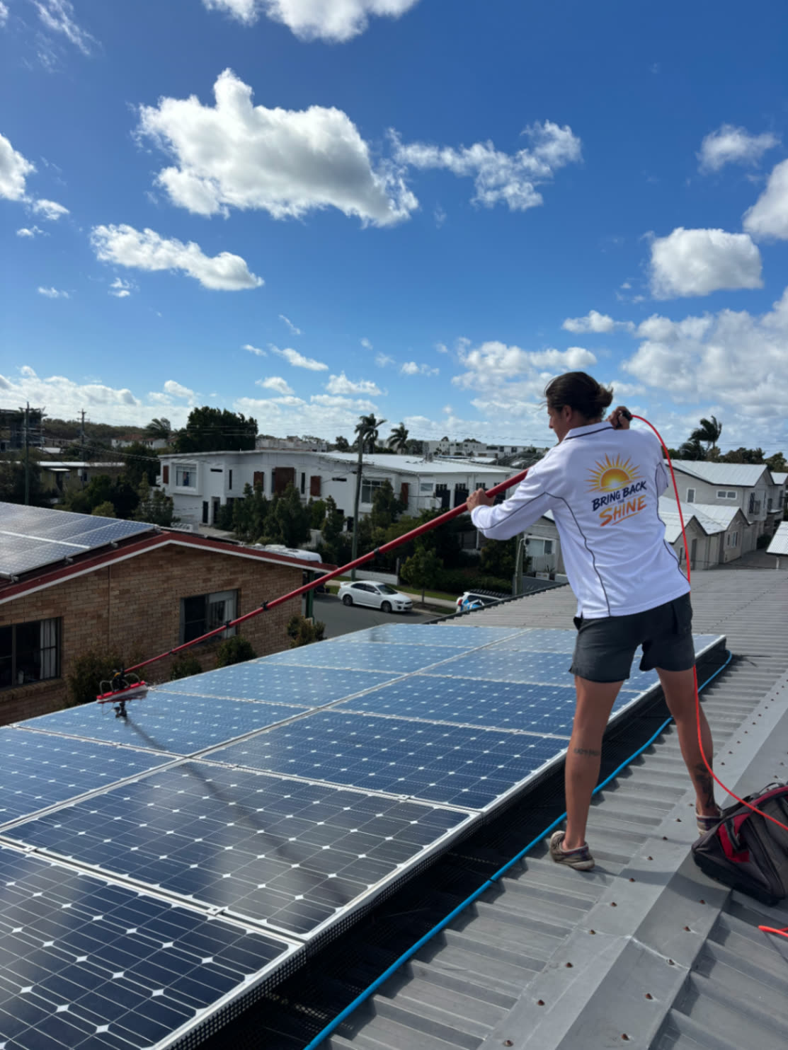 Sunny Scrubbers crew rinsing a rooftop solar array with a pure water pole
